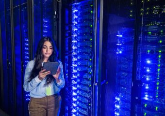 Woman technician using digital tablet in server room